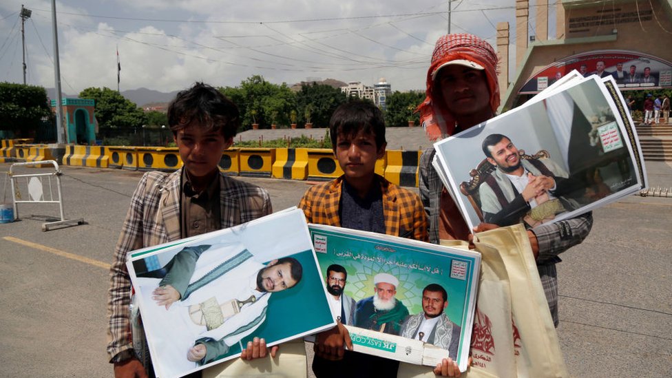 Jóvenes yemeníes con fotografías del líder rebelde hutí