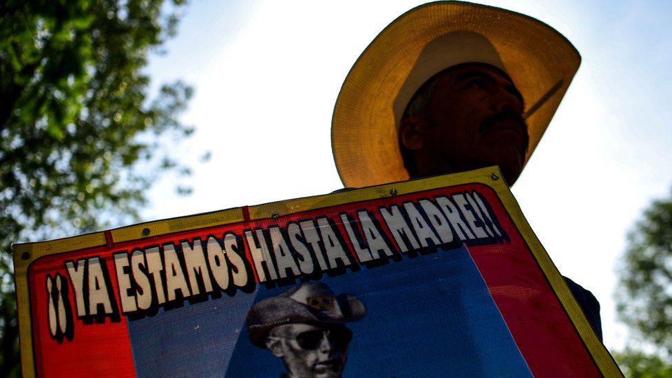 Manifestante en México con cartel de 