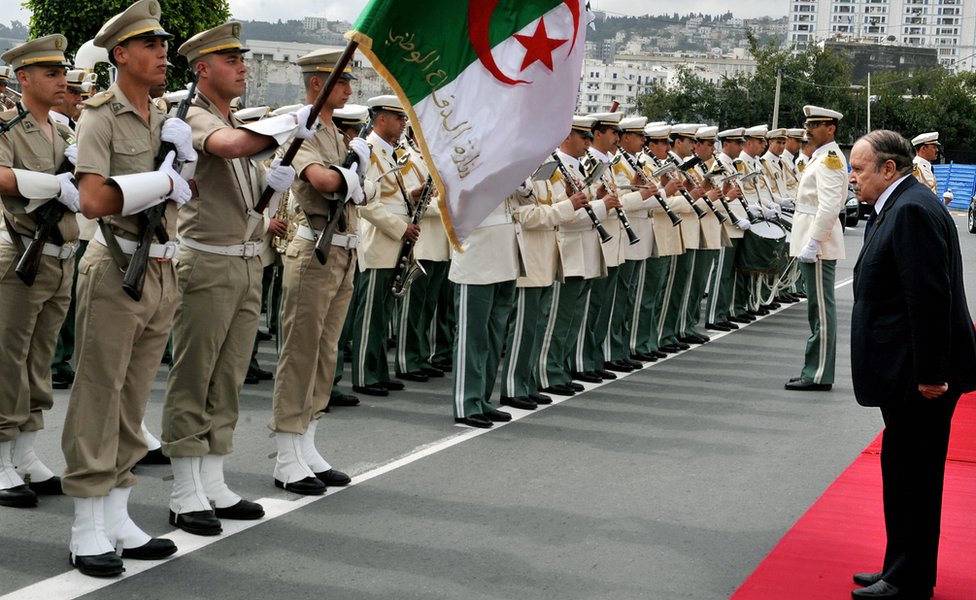 Президент Алжира Абдельазиз Бутефлика (справа) приветствует национальный флаг, рассматривая почетный караул в Алжире - 2009