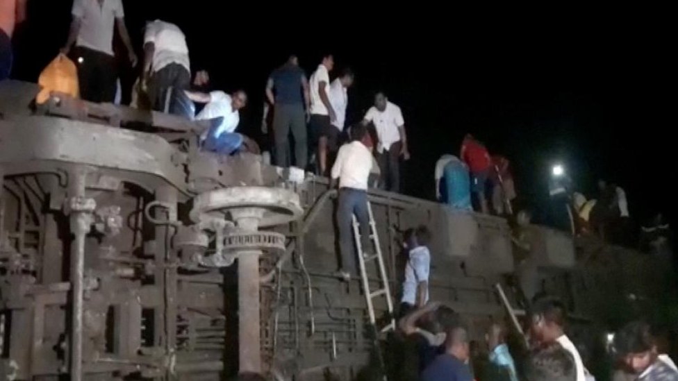 People try to escape from toppled compartments following the crash