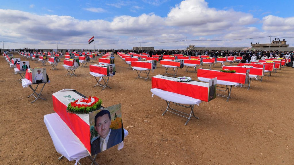 Coffins are spaced out at the mass funeral in Kocho on 6 February 2021