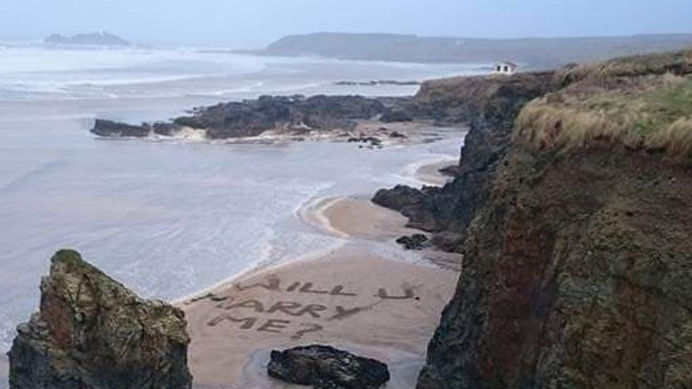 "Ты выйдешь за меня?" написано на песке
