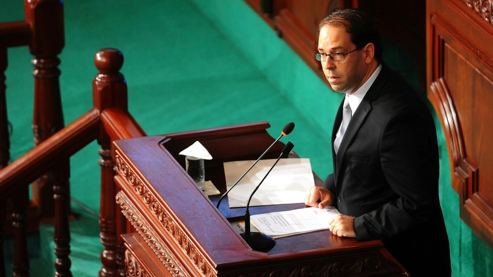 Новоназначенный премьер-министр Туниса Юсеф Чахед (в центре) выступает с речью в парламенте Туниса в пятницу, 26 августа 2016 г., в преддверии вотума доверия.