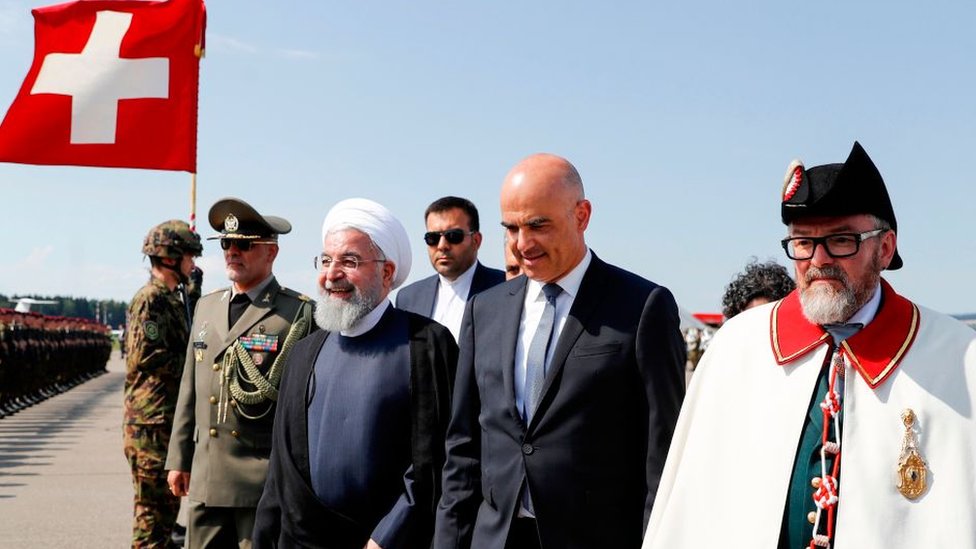Iranian President Hassan Rouhani (3rd left) walks with Swiss Federal President Alain Berset (C) at an airport in Kloten on 2 July 2018
