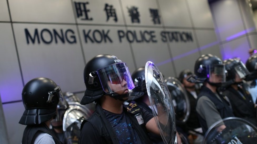 ОМОН Гонконга стоит на страже, пока антиправительственные протестующие собираются возле полицейского участка Монг Кок
