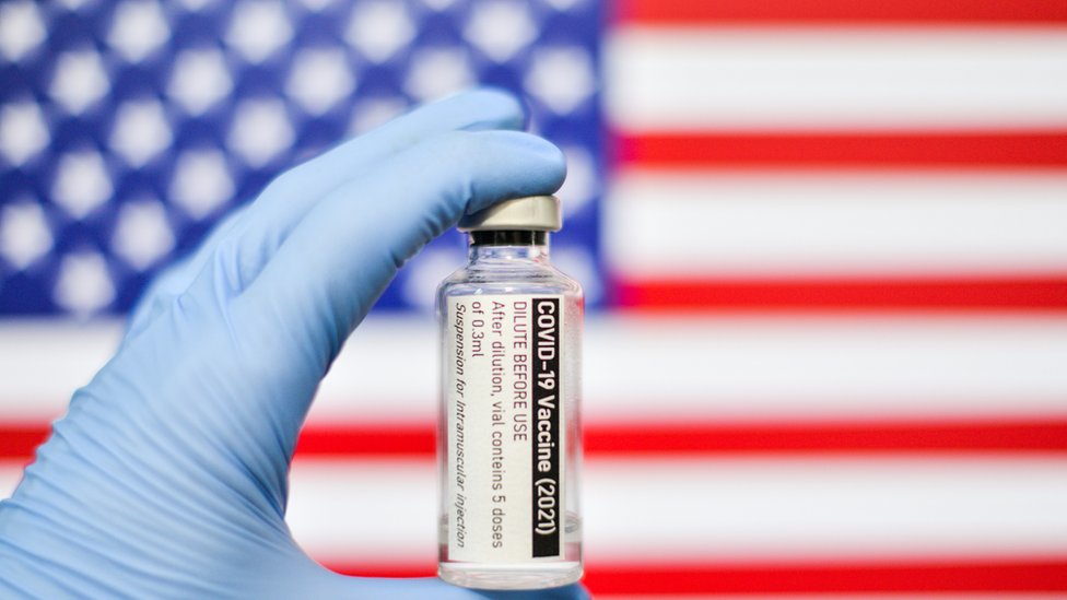 Vacina em frente a bandeira dos Estados Unidos