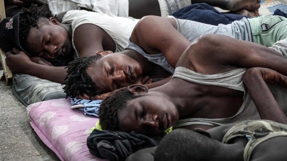 Незаконные иммигранты спят в центре заключения в Ливии