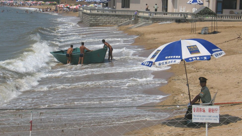 Un guardia de seguridad vigilando una playa privada.