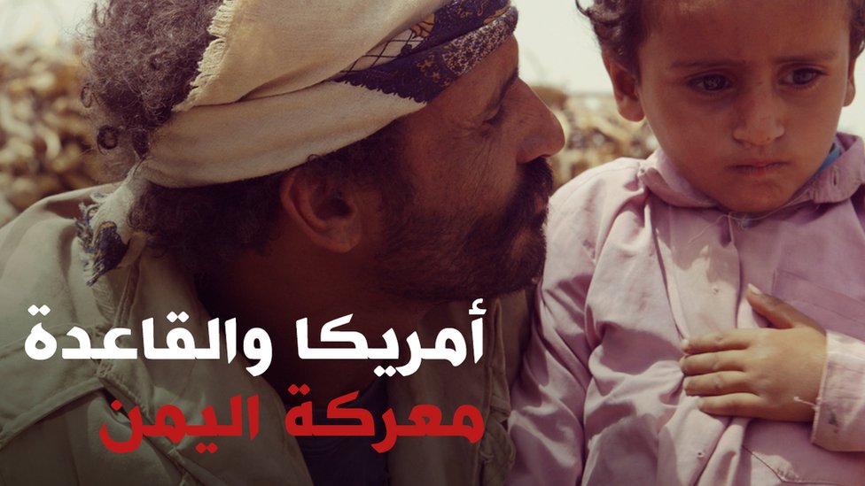 رجل يمني ينظر إلى ابنه الصغير