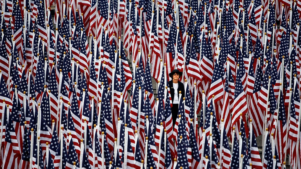 Una mujer camina entre unas 3.000 banderas de EE.UU. que forman el "Campo de Sanación" afuera del Pentágono, el 11 de septiembre de 2008, en Arlington, Virginia.