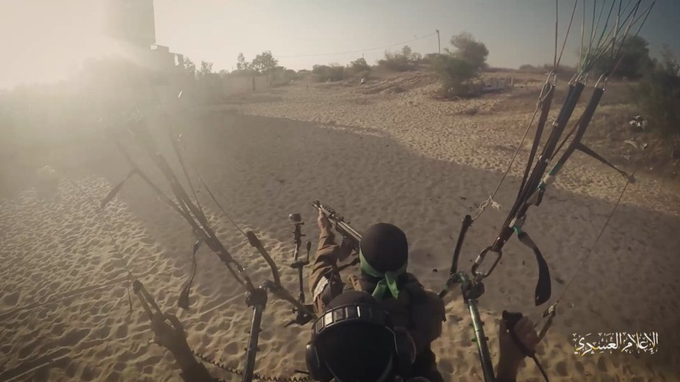 一名哈馬斯戰鬥人員坐在降傘搭載的跳傘統攻籠子裏舉起機槍