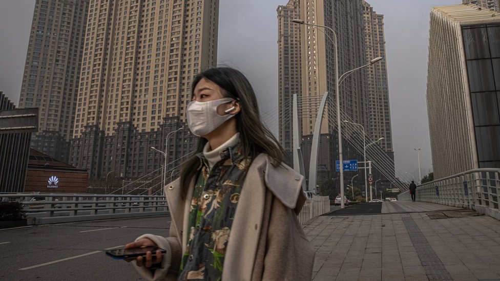 Mulher jovem usando uma máscara facial, em Wuhan, China.