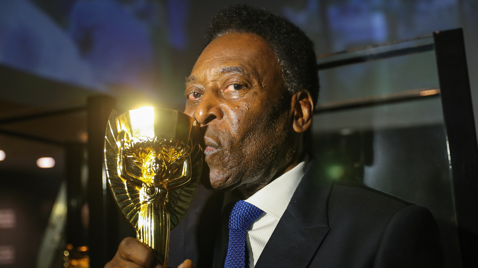 At the Museum of the Brazilian National Team, Pelé kisses a replica of the Jules Rimet Cup, won by Brazil at the 1970 World Cup in Mexico.
