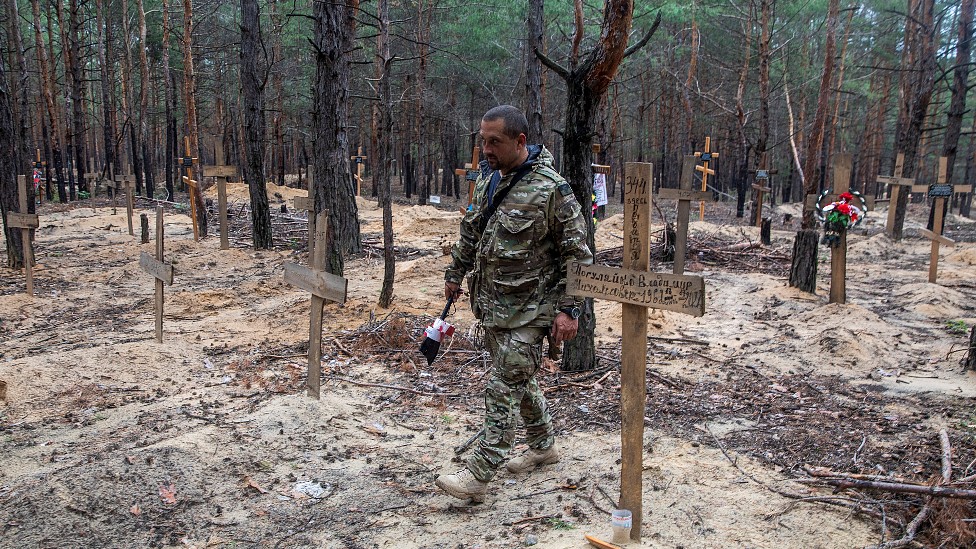 Un soldado de Ucrania camina entre cruces de madera