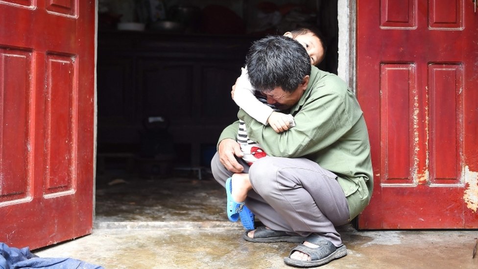Le Minh Tuan abraza a su nieto.