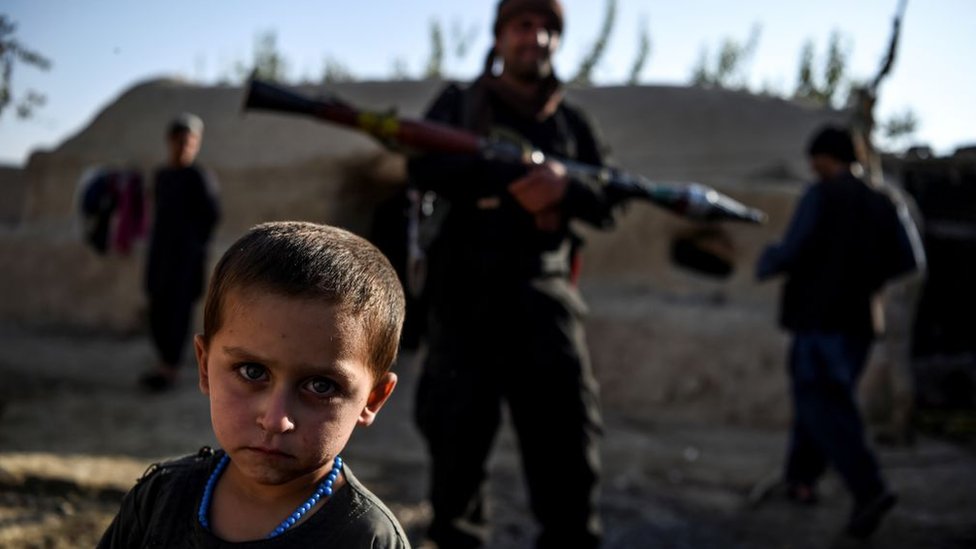 Un niño junto a policías en Afganitán