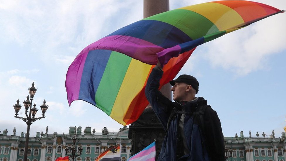 A participant waves a rainbow flag