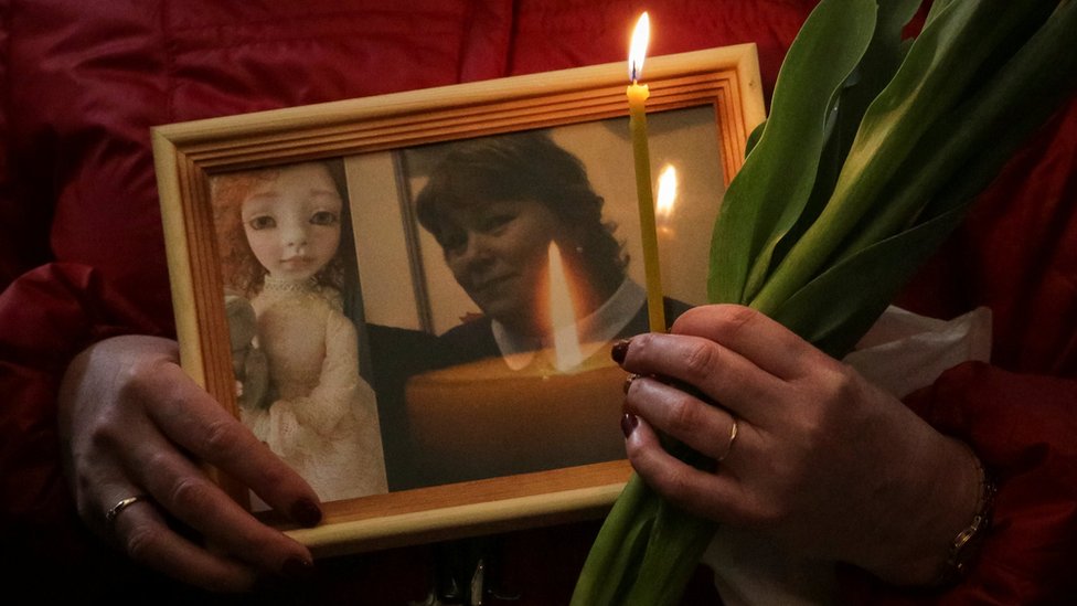 Родственник держит фотографию потерпевшей Ирины Медянцевой на поминальной службе в Санкт-Петербурге