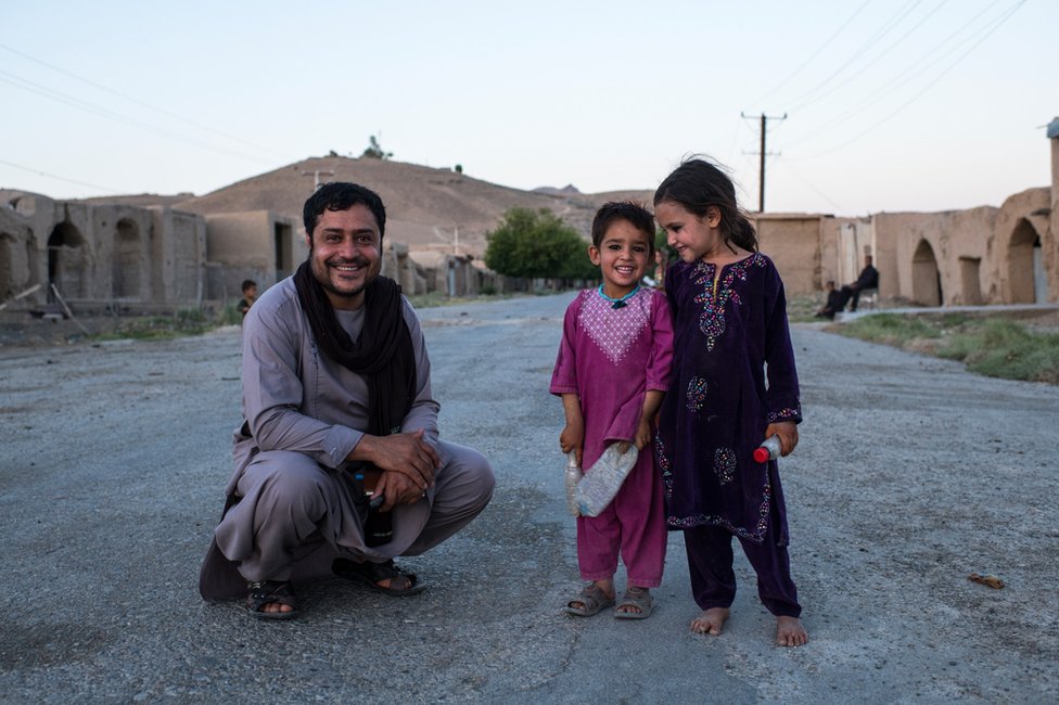 Aliyas Dayee with local kids on the main road of the largely abandoned Tangay Bazaar, in government-controlled Kajaki.