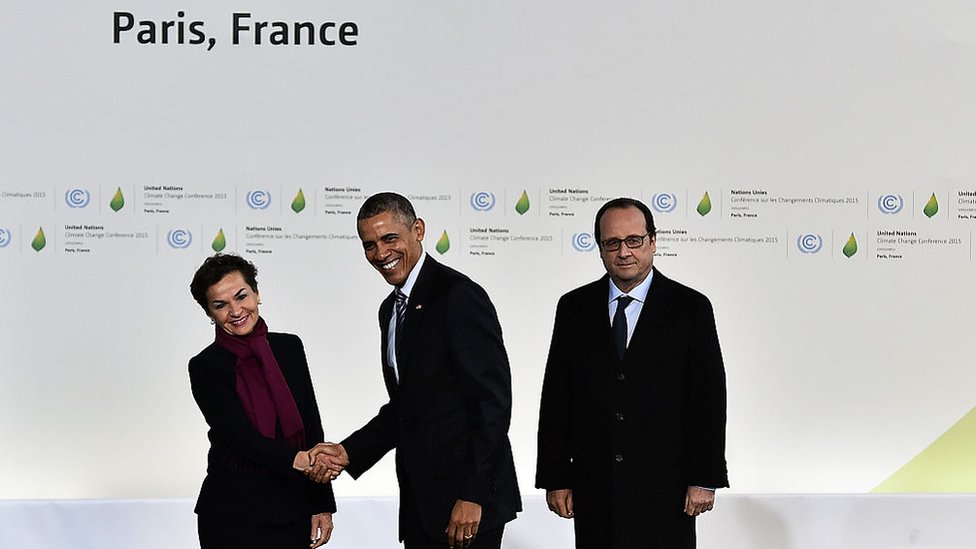 Barack Obama estrecha la mano de la jefa contra el cambio climático de la ONU, Christiana Figueres, ante Francois Hollande, París en 2015. Christiana Figueres, Barack Obama y Francois Hollande en París durante la Cumbre Climática de 2015.