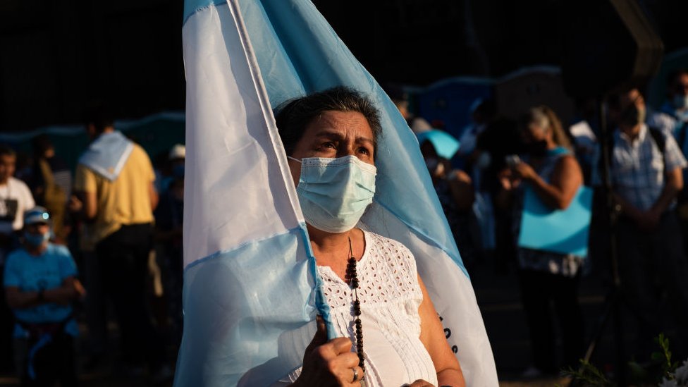 Manifestante frente al Congreso con la bandera de Argentina.