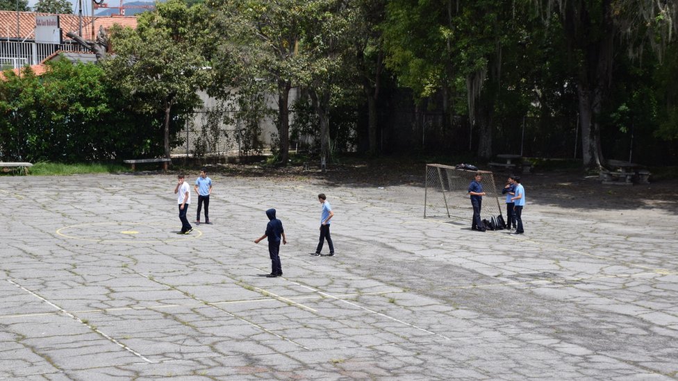 Ученики играют в футбол во дворе школы