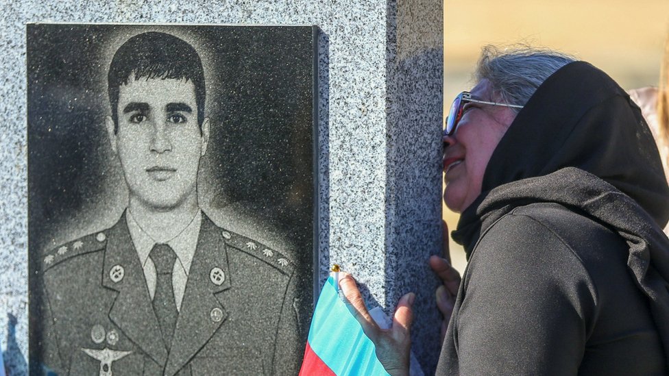 Žena ljubi spomenik azerbejdžanskog vojnika koji je poginuo u sukobu u regionu Nagorno-Karabah, 27. septembar 2021.