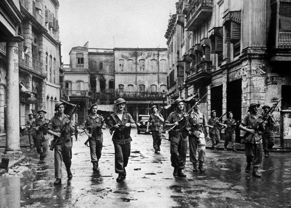 British troops in Calcutta, with rifles at the ready, clearing a street after Hindus and Muslims used firearms against each other
