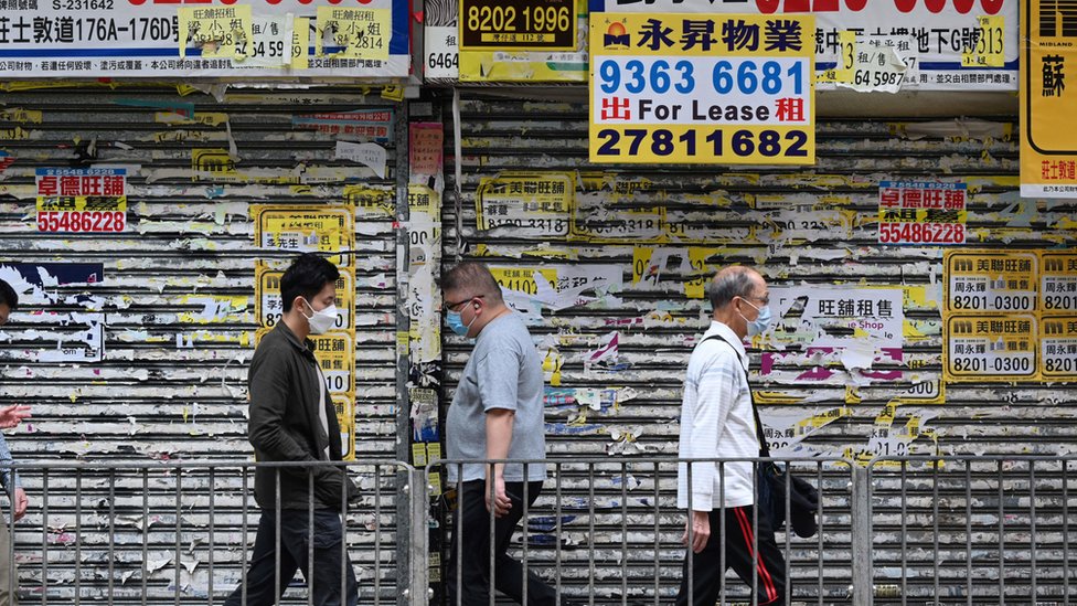 香港市民走過一家已倒閉的商店（19/10/2022）