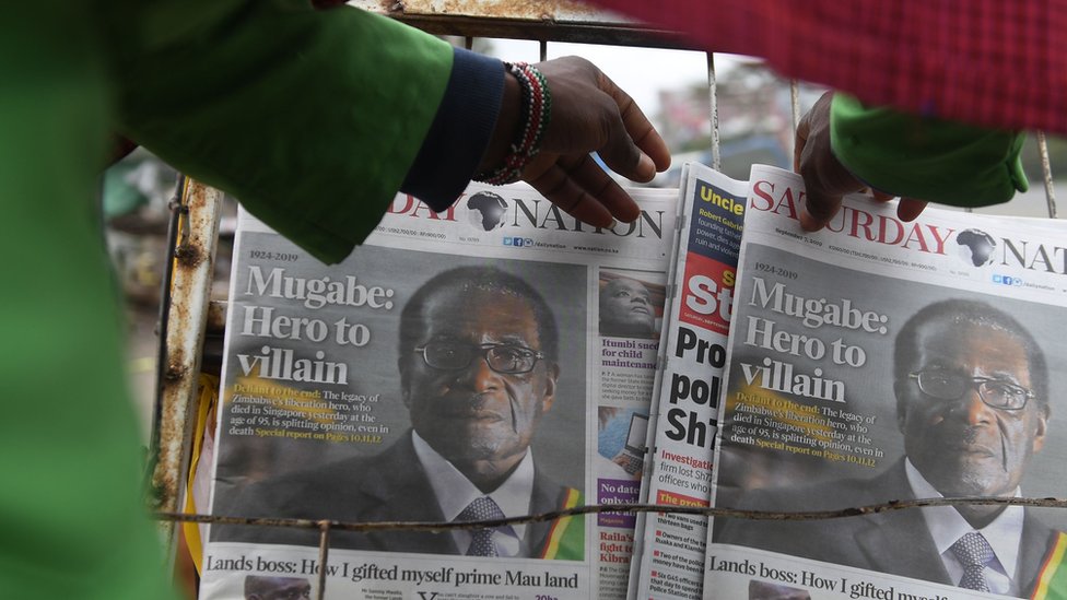 Мужчина покупает ежедневную газету на стенде на улицах Найроби после смерти Роберта Мугабе
