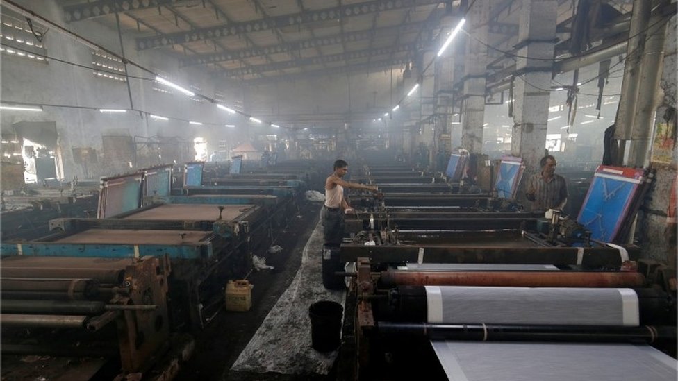 Сотрудники работают в сари, традиционной женской одежде, производственная фабрика в Сурате, Индия, 8 марта 2019 г.