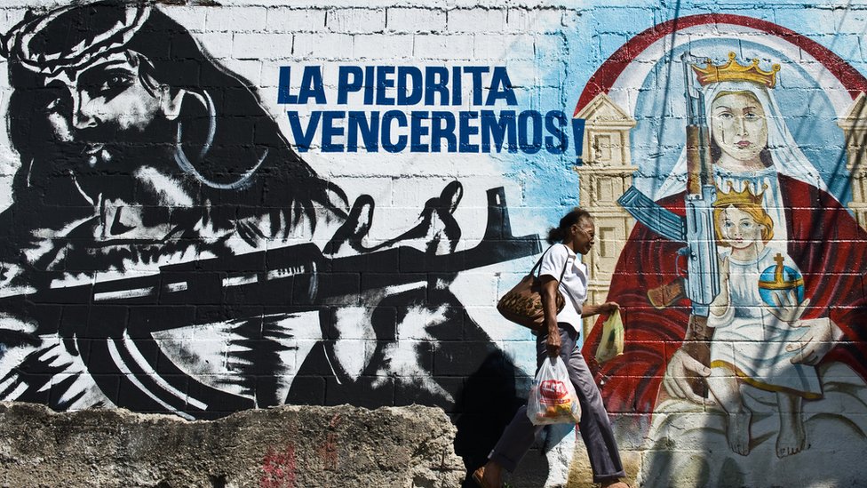 Los grupos consultados por BBC Mundo aseguran rechazar la violencia, aunque no la descartan si se sienten atacados. Mural en el 23 de enero que muestra un Cristo y una virgen armados.