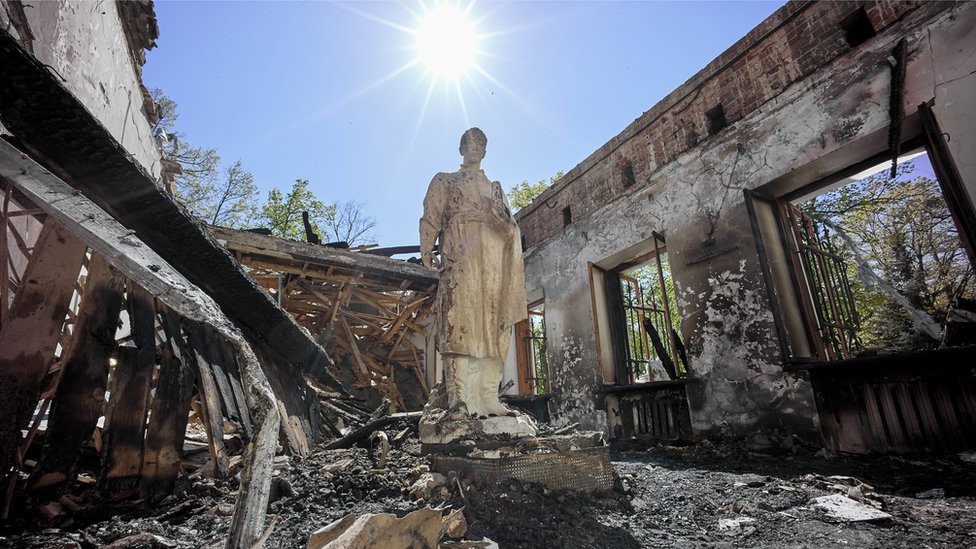 La estatua del poeta ucraniano Grigory Skovoroda en medio de las ruinas de su casa museo