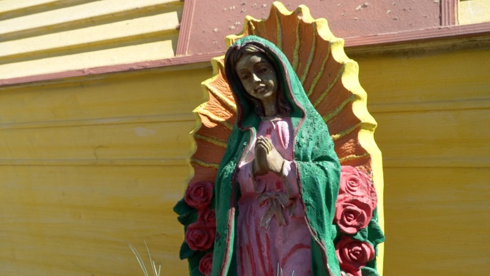 Vírgen de Guadalupe frente a una casa-trailer en Escobares.