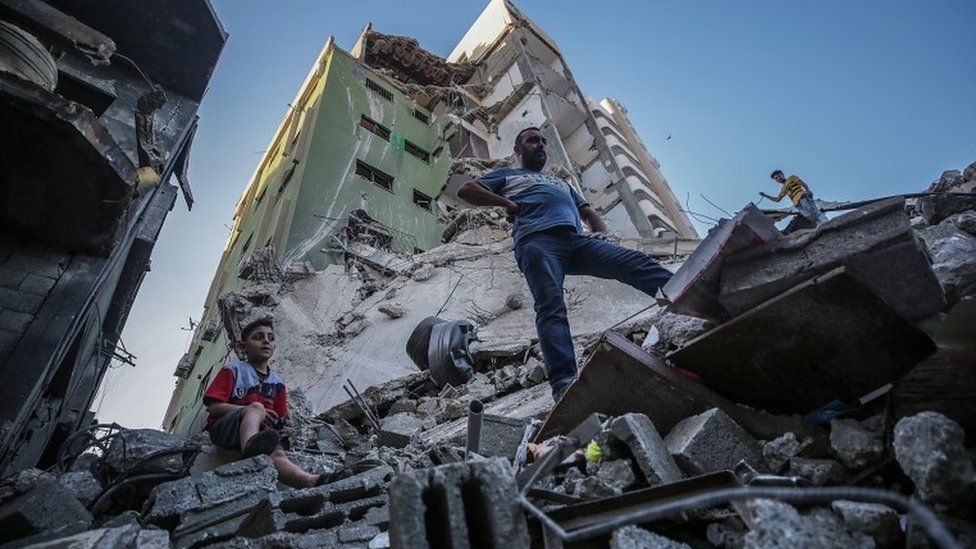 Palestinians inspect the rubble of their destroyed house after Israeli airstrikes