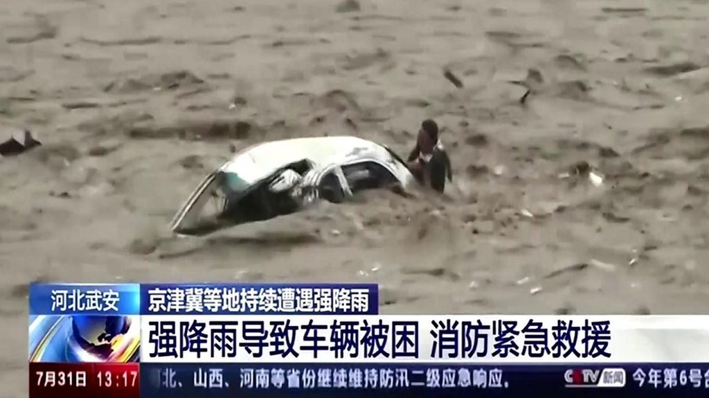 China floods: Man rescued from overturned car