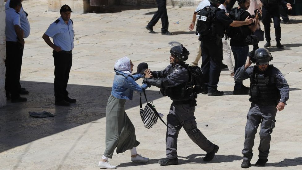 رجل شرطة إسرائيلي يدفع امرأة فلسطينية في المسجد الأقصى صبيحة عيد الفطر