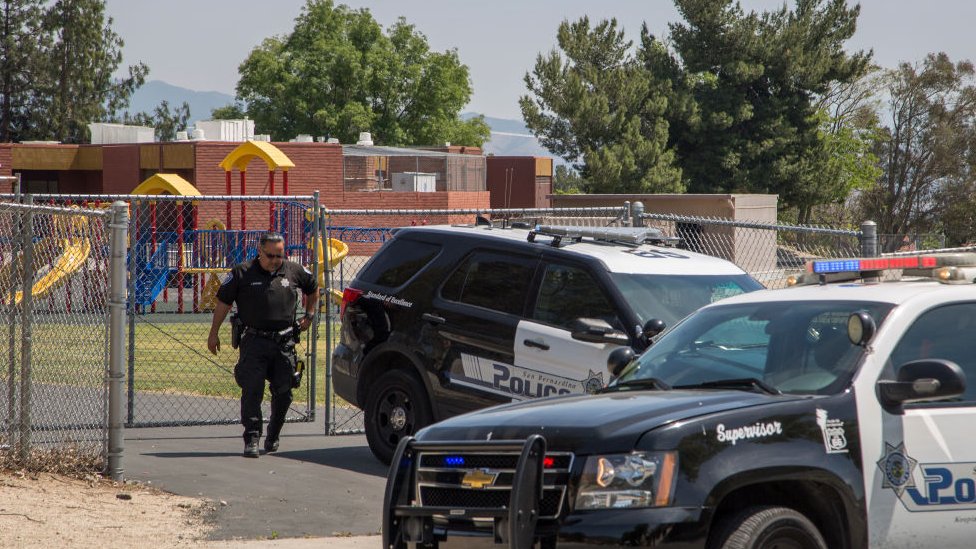 Agente de la policía saliendo de una escuela en California.