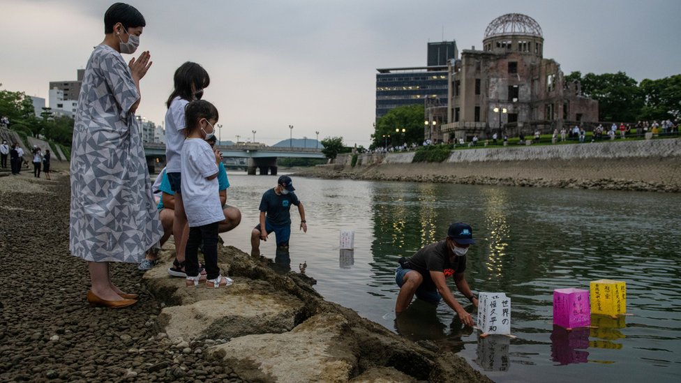 廣島原爆遺址對岸一家大小朝著給放到天滿川上的祈福水燈合十（6/8/2020）
