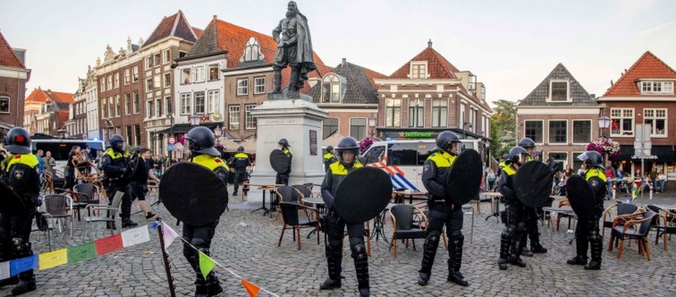 Полиция стоит на страже у статуи Яна Питерсоона Коэна в Хорне, 19 июня 2020 г.