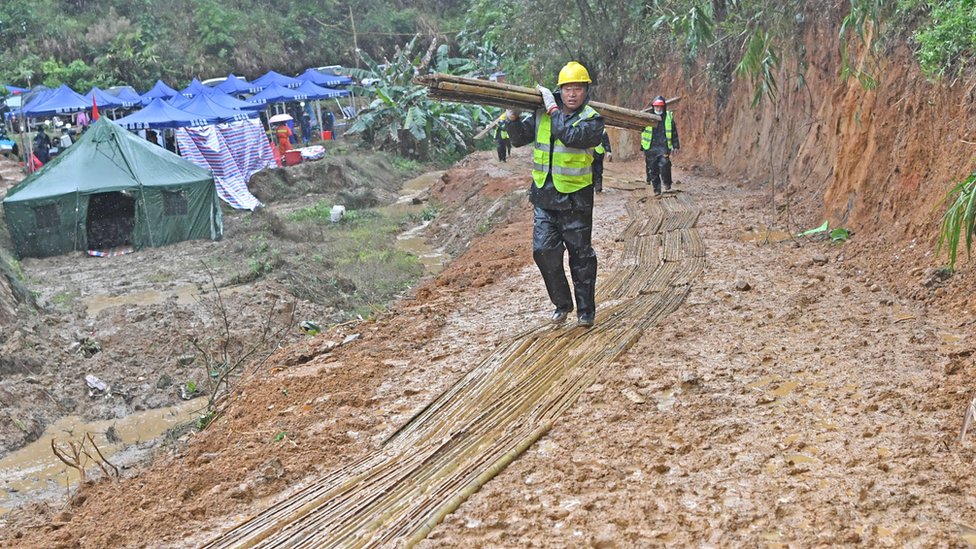 廣西梧州藤縣中國東航MU5735航班墜落事故墜落現場工作人員在鋪上竹子的泥濘路面上行進（新華社圖片23/3/2022）