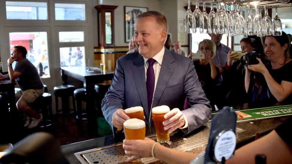 Anggota partai buruh Anthony Albanese membeli bir untuk para pendukungnya di sebuah pub di Sydney.