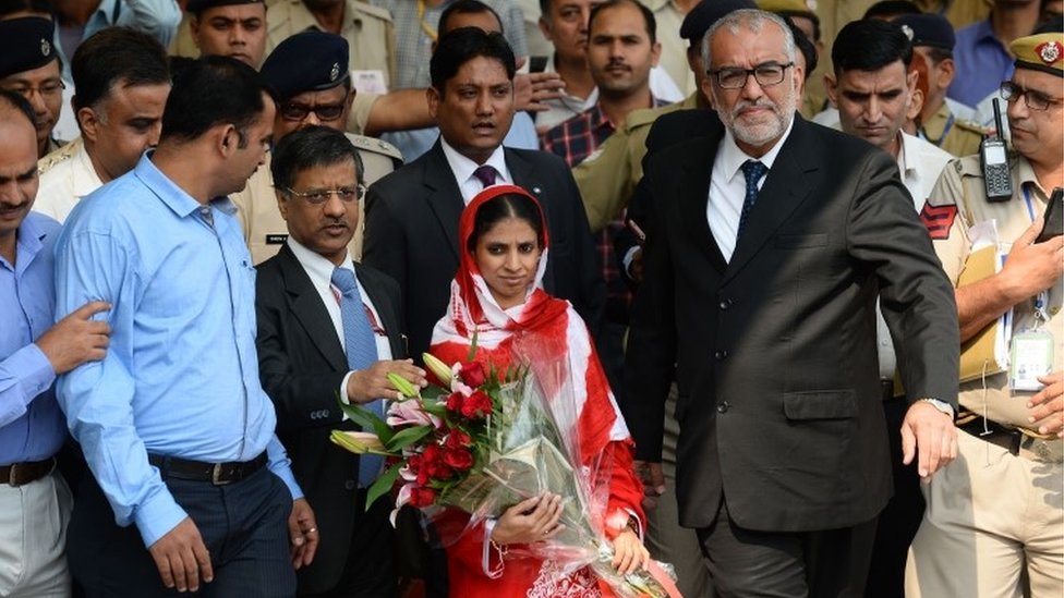 Глухонемая индийская женщина "Гита" (в центре) в сопровождении официальных лиц выходит из зала прибытия международного аэропорта Индиры Ганди в Нью-Дели 26 октября 2015 года после прибытия из пакистанского города Карачи.