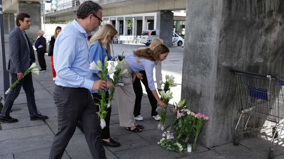 People laying flowers near the site of the shooting on 4 July