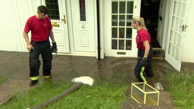 Firefighters in Romford work to pump flood water away from homes