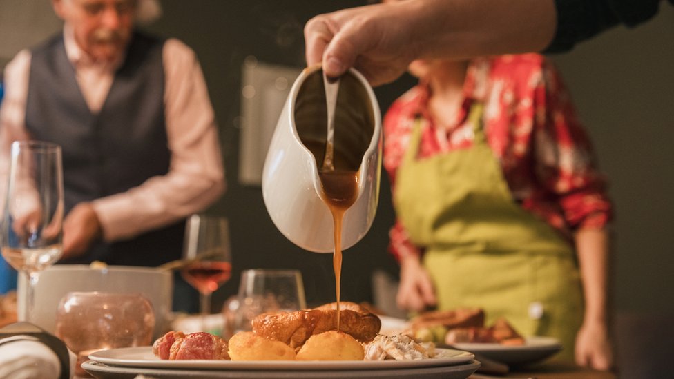 Photo of gravy being poured out of a gravy boat at Christmas dinner