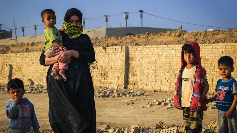 امرأة عاملة تغطي وجهها لحماية نفسها من الغبار وأشعة الشمس في بغداد في 7 مارس/ آذار 2023