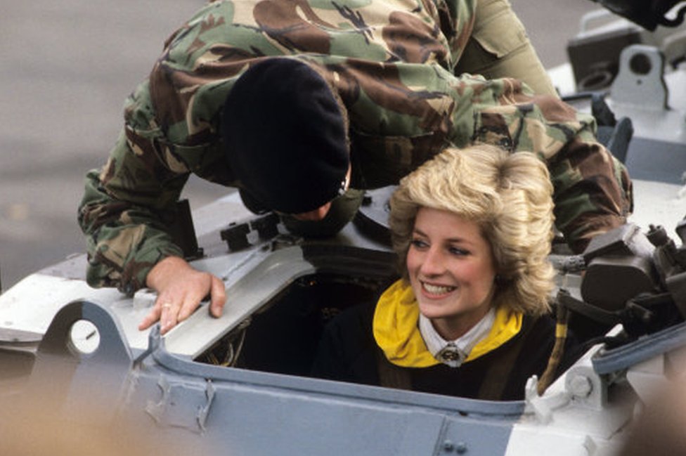 Diana en un vehículo militar acompañada de un soldado