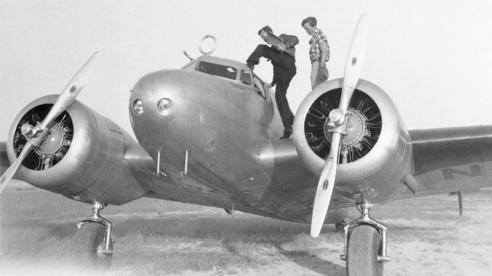 Нунан і Ерхарт оглядають свій літак Lockheed