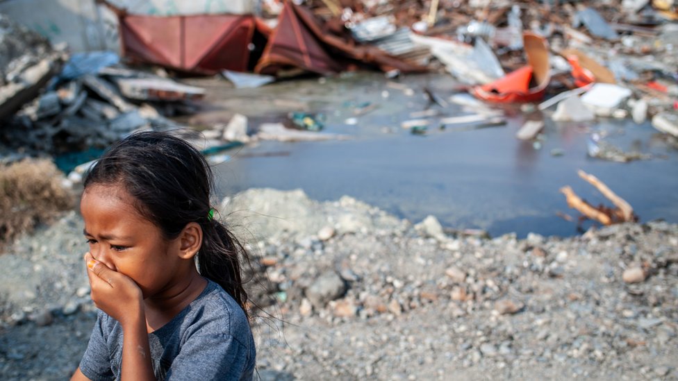 Una niña no identificada camina cerca de las ruinas de un edificio destruido por el terremoto